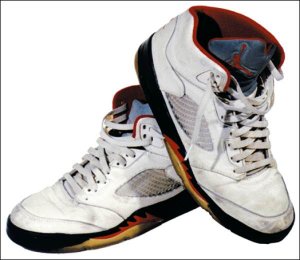Air Jordan 5, front and side view, white with black, red, and yellow accents
