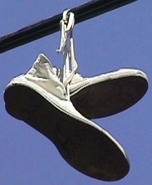 Converse "Chuck Taylor" white high-top sneakers hanging from a utility line