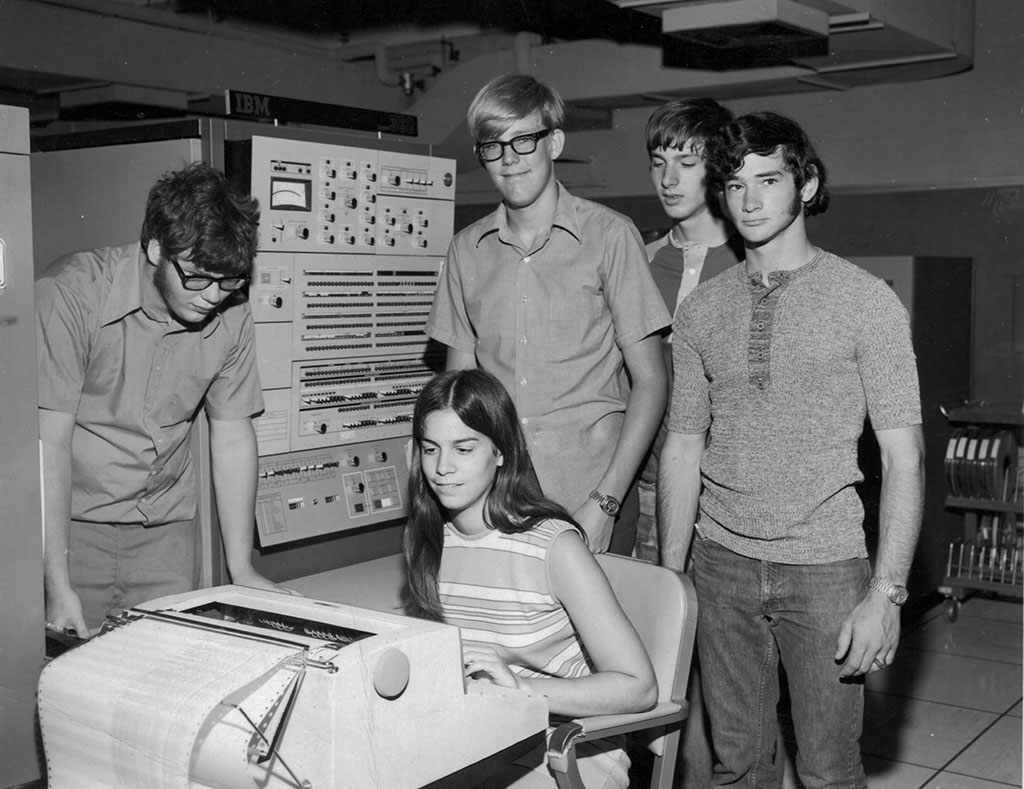 STEM geeks looking intently at a vintage computer (IBM System/360 Model 50)